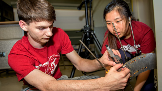 Two students building a breast cancer detection device.